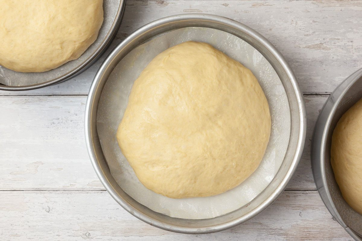 Step 5 of Taste of Home Hawaiian Sweet Bread is to Shape each into a ball. Place the dough in three greased 9-inch round baking pans lined with parchment. Cover and let the dough rise until doubled, about 45 minutes.
