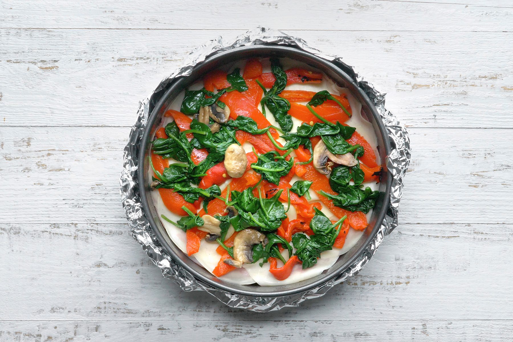 Layer crust with half each of the following: ham, salami, provolone cheese, red peppers and spinach mixture.