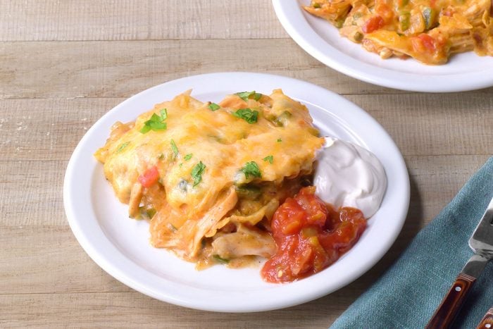King Ranch Casserole served in a plate with sour cream and salsa