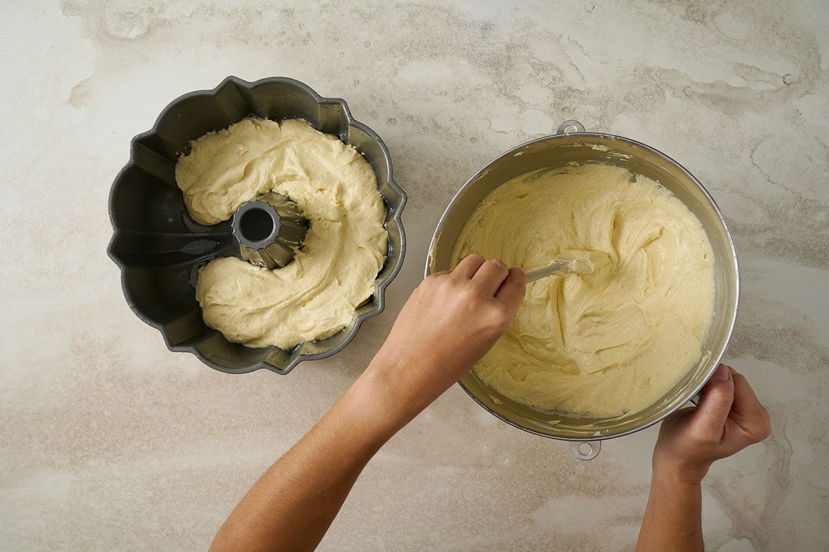 Overhead view of the lemon pound cake batter poured into a greased fluted tube pan, ready to bake for the Taste of Home Lemon Pound Cake recipe.