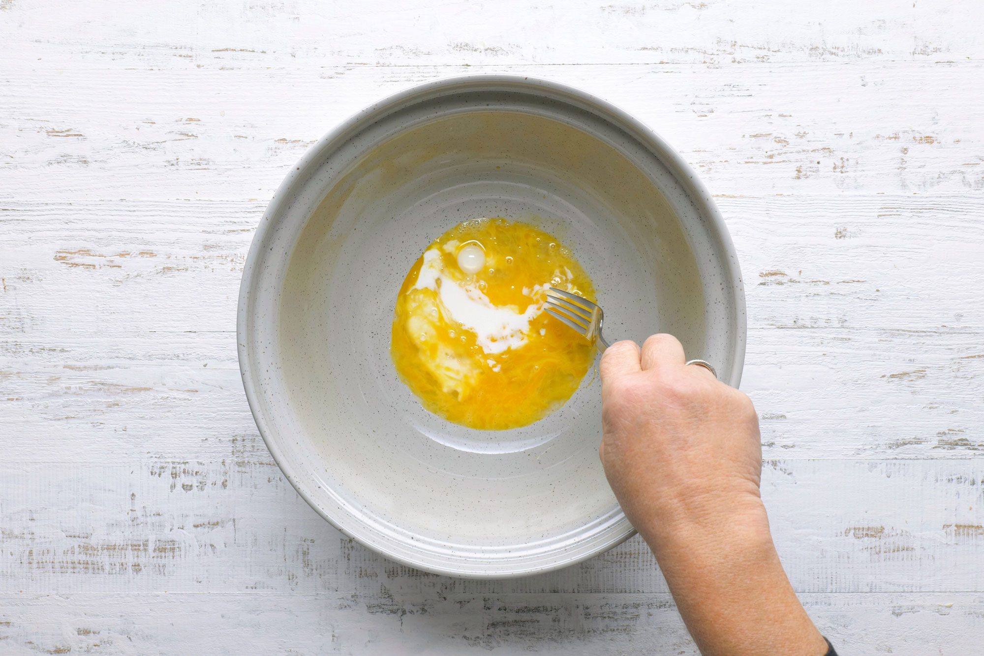 In a large bowl combine eggs and milk with fork
