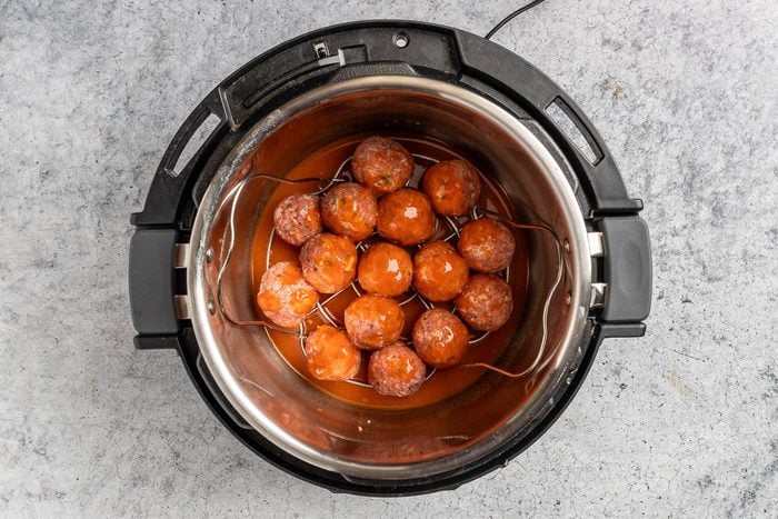 Taste of Home Meatballs and Rice photo of the formed meatballs in the slow cooker topped with the sauce.