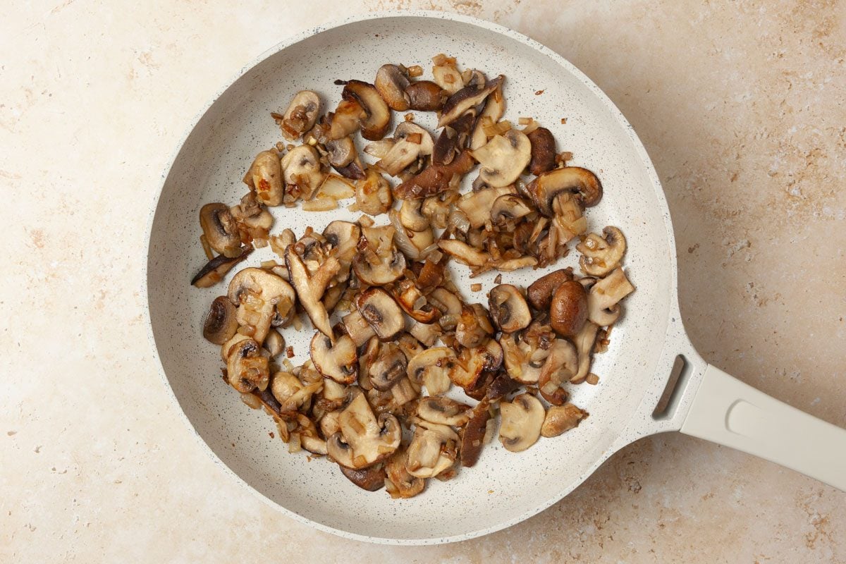 Step 1 of Taste of Home Mushroom Bruschetta is to cook the onions and mushrooms