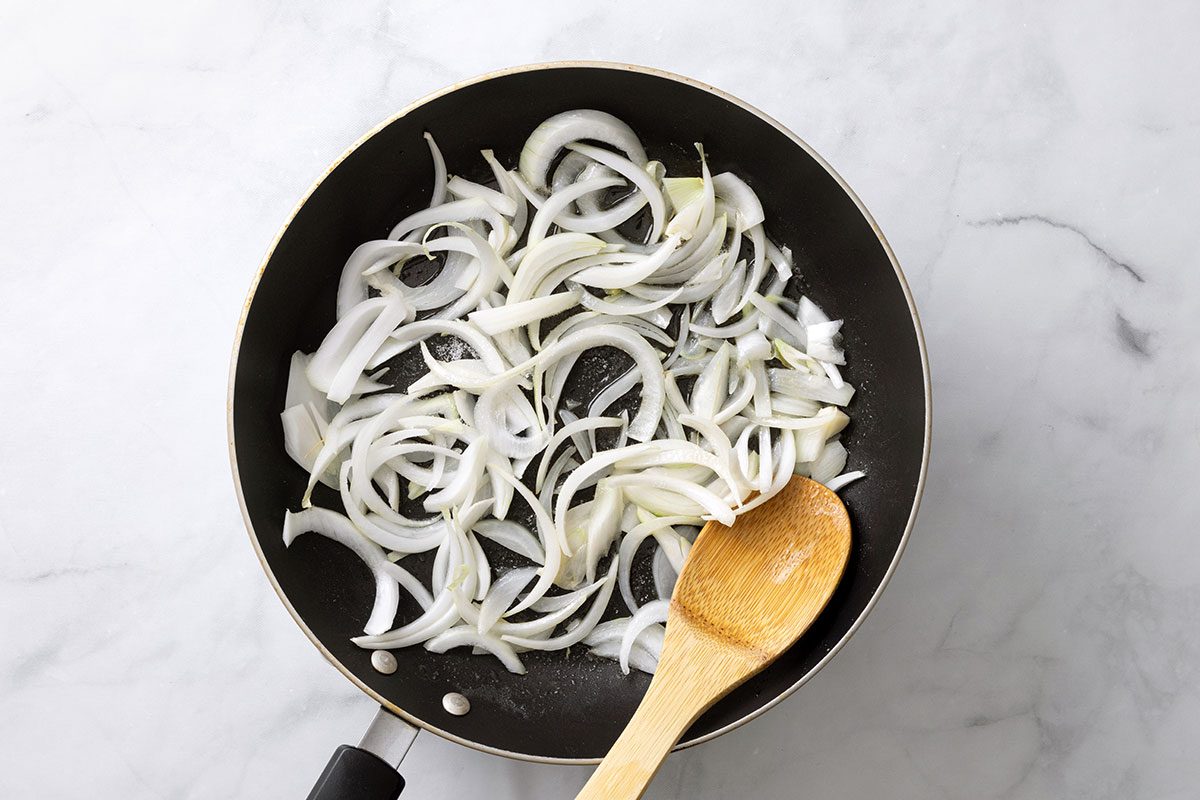 Onion and sugar in butter cooking a large skillet for step one for Onion Mashed Potatoes for Taste of Home