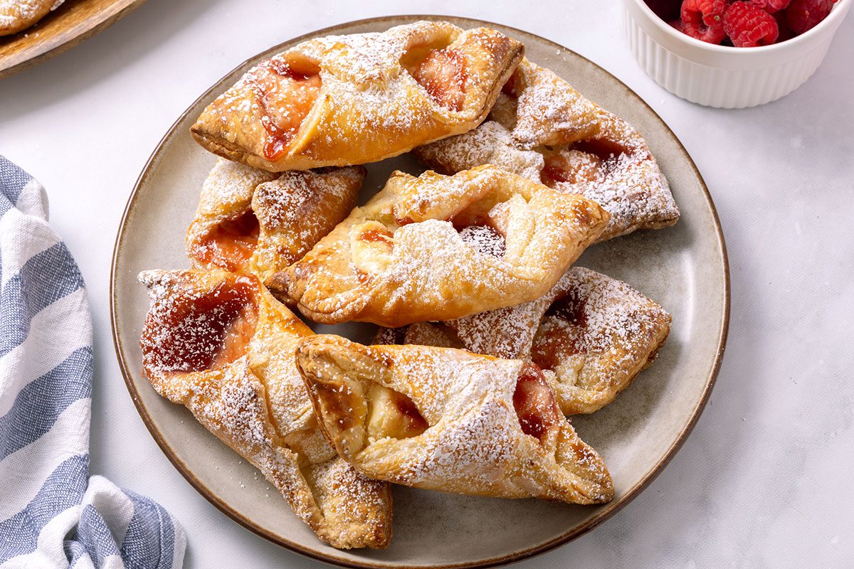 Puff Pastry Danishes topped with powdered sugar on a serving plate for Taste of Home