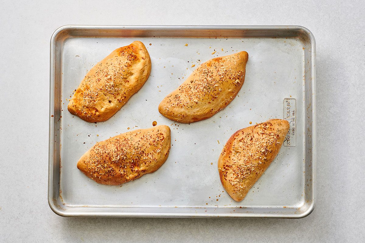 Baked pepperoni calzones on a baking sheet