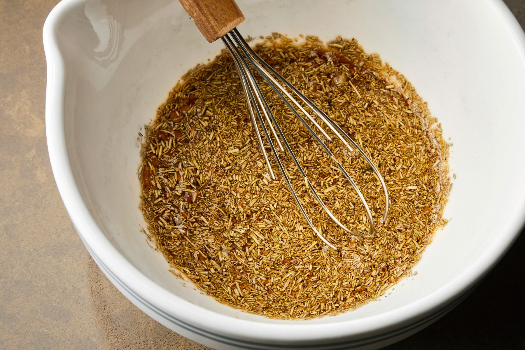 overhead shot of Stiring in a half cup water in dry ingredients with a whisker