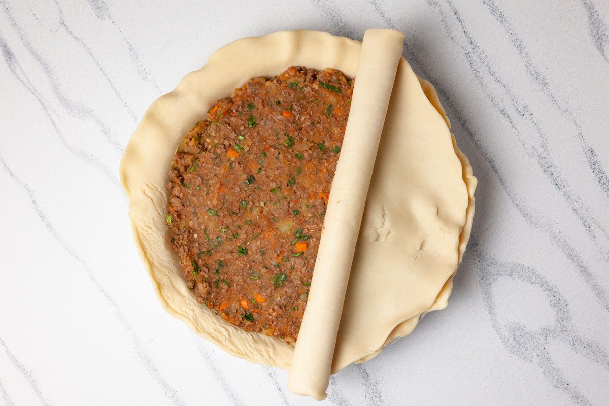 Step 3 of Taste of Home Savory Meat Pie is to add the filling in the crust