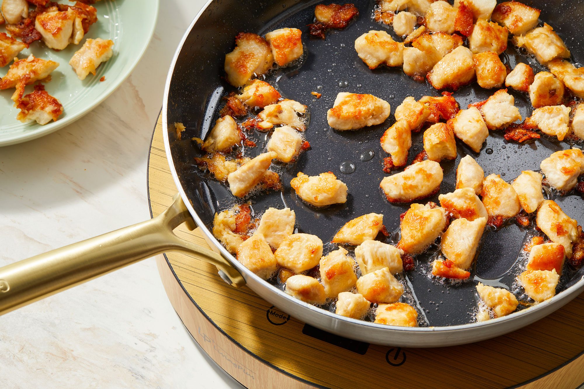 In a large skillet or wok heating oil over medium high heat then add chicken and cooking until crispy and golden on all sides
