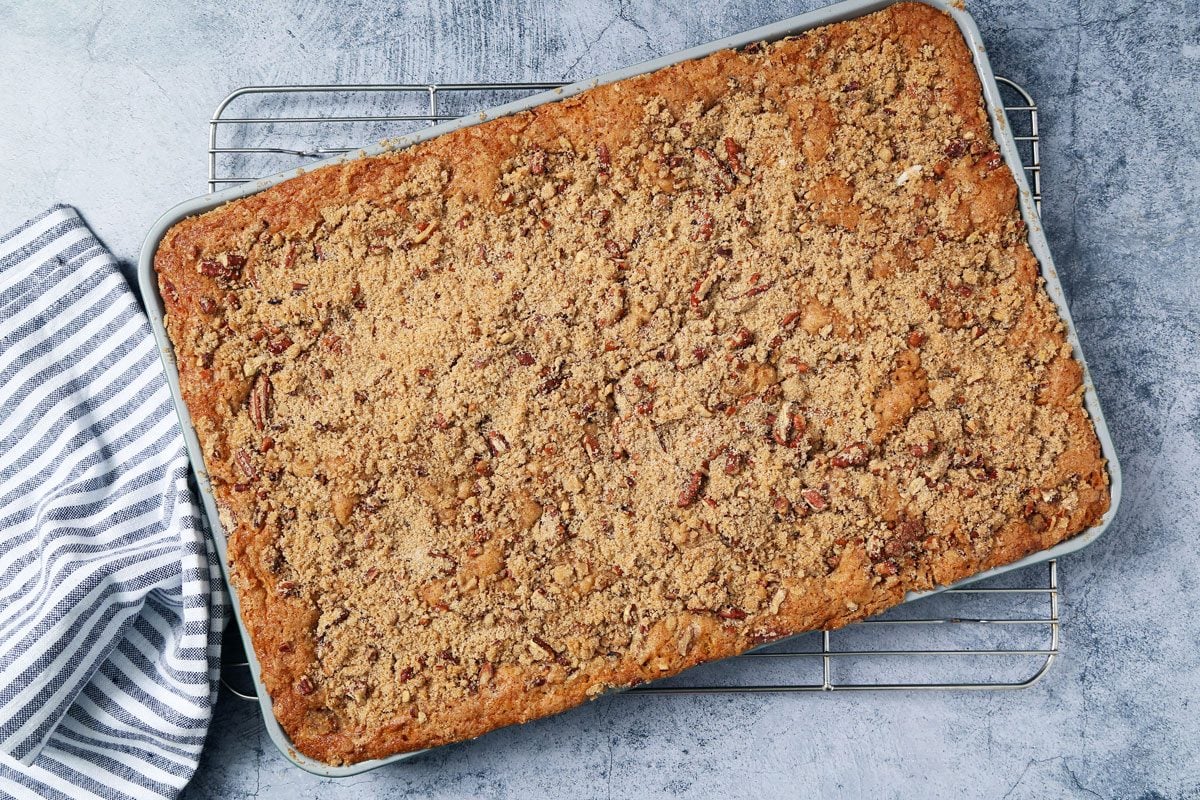 Process of making Taste of Home's Buttermilk Coffee Cake cooling on a wire rack on a light blue surface.