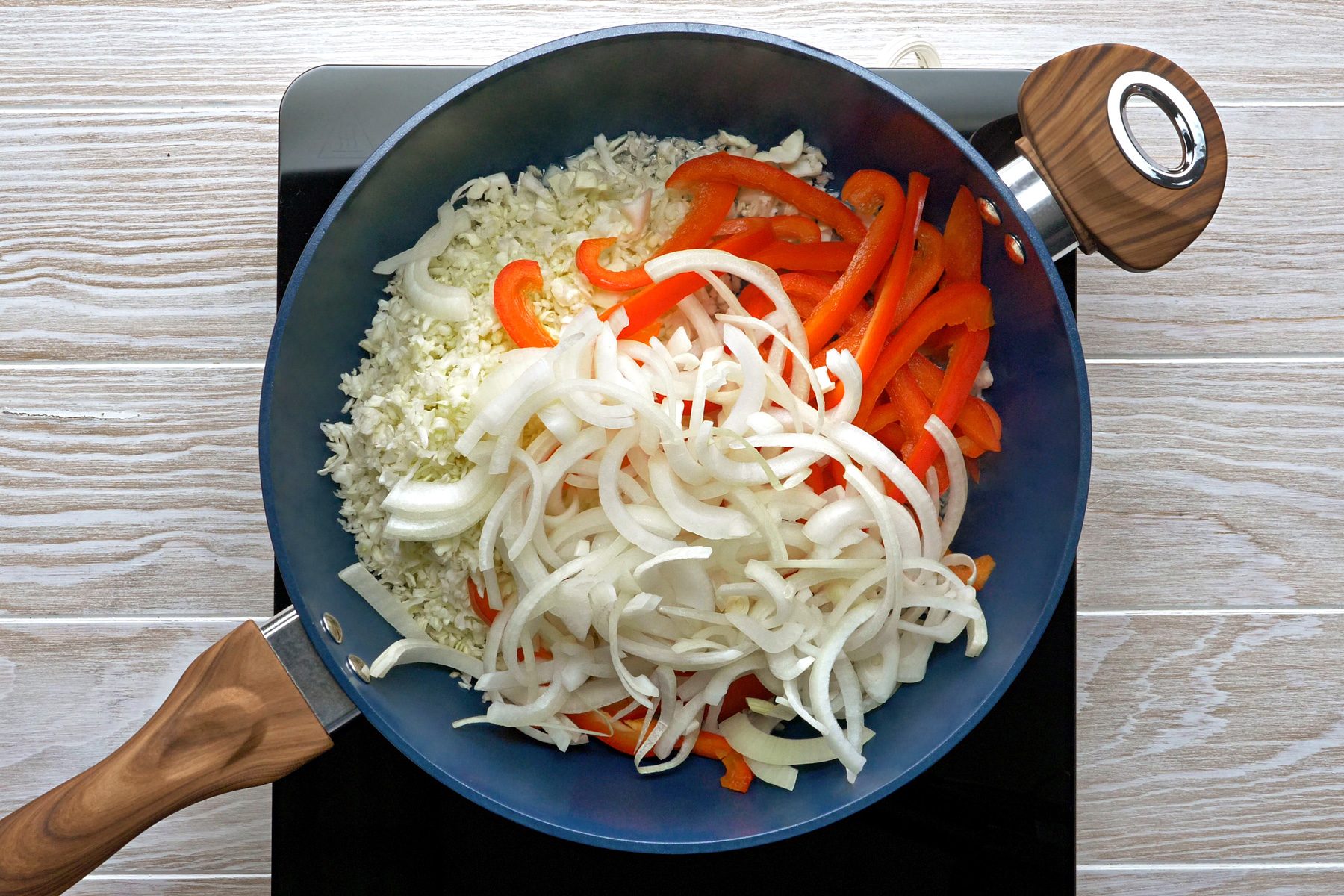 A variety of vegetables cooking in a skillet.