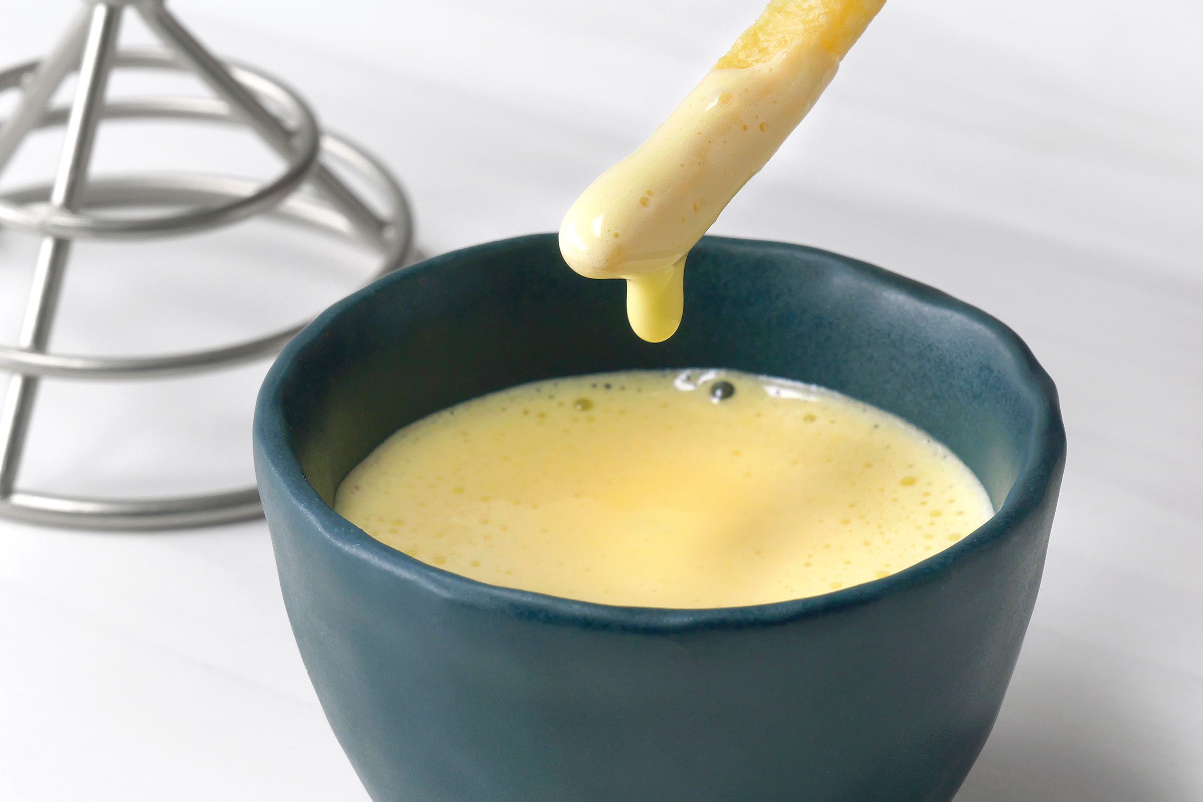 Fries dipped in Aioli in a small bowl