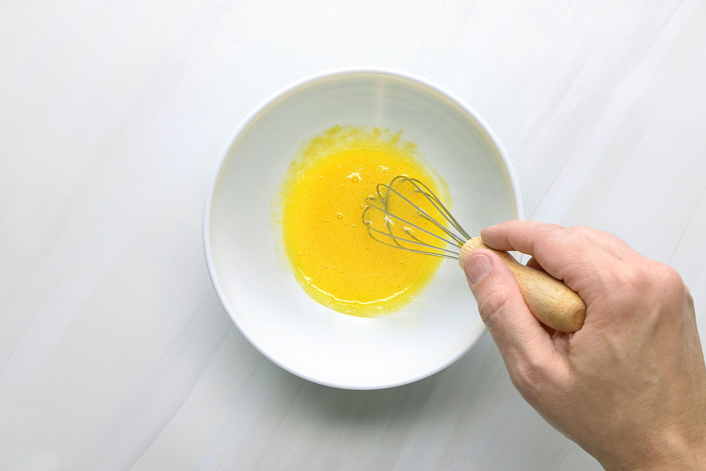 Egg yolk, garlic and lemon juice whisked in a bowl together