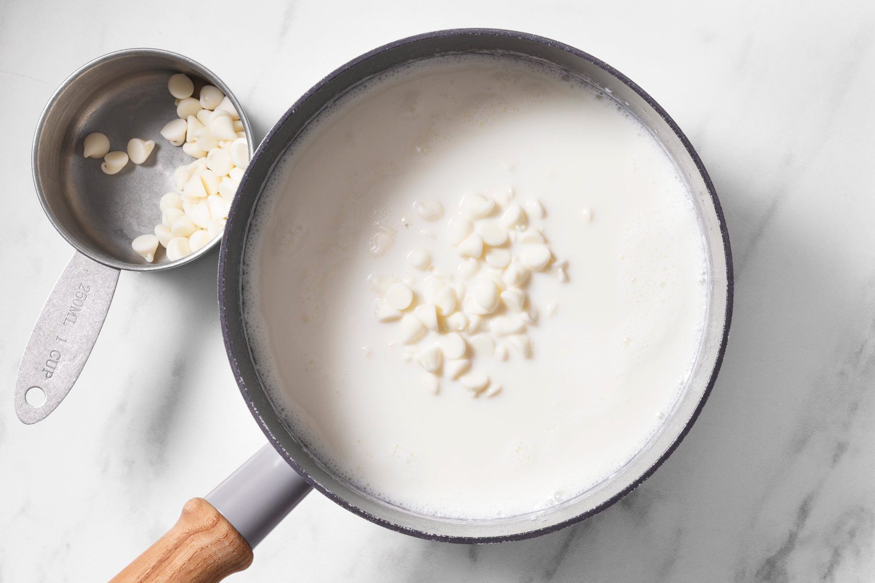 Pour milk into a small saucepan, Stir in white chocolate until melted,