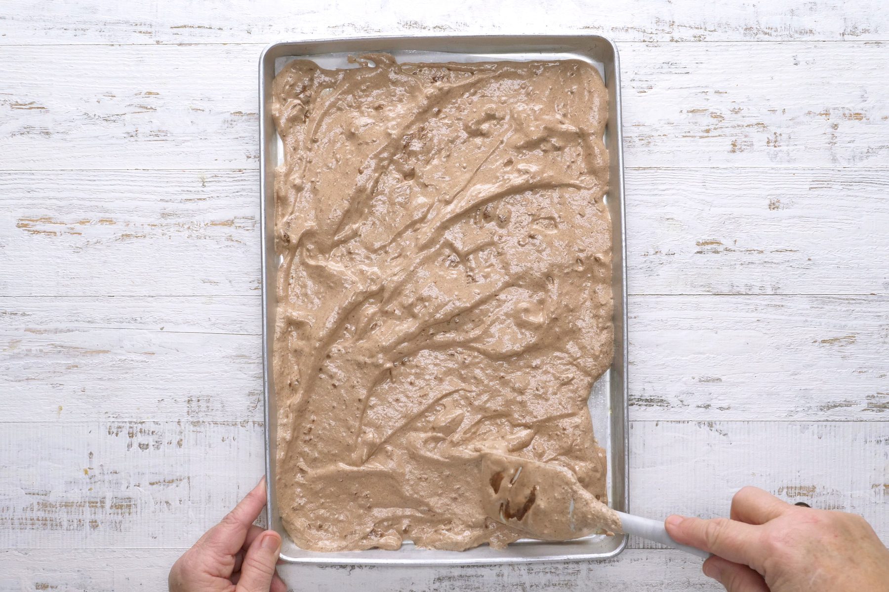 Spreading the mixture evenly into the prepared pan.