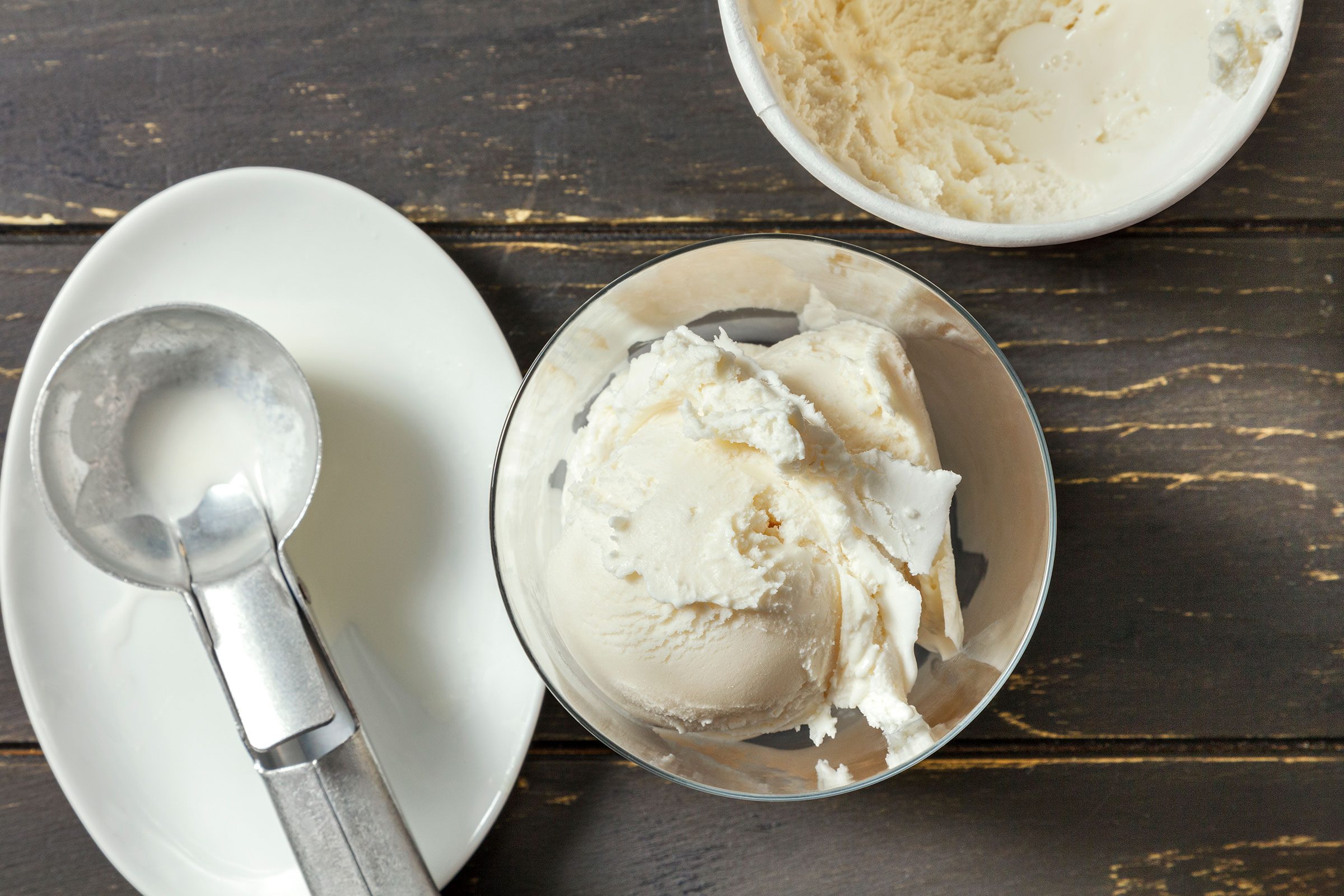 Vanilla ice cream in the glass with an ice cream scooper on side