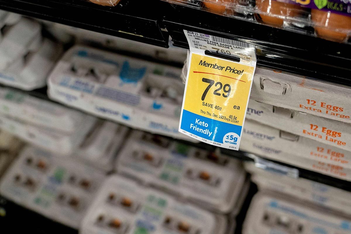 Price tag in the egg shelves of a grocery store with many egg cartons in the background
