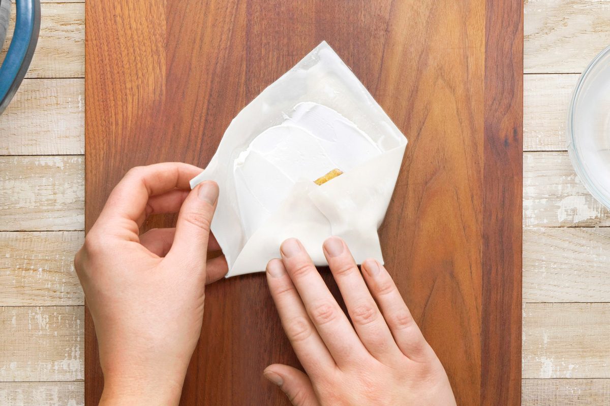 egg roll wrapper being folded to form a roll