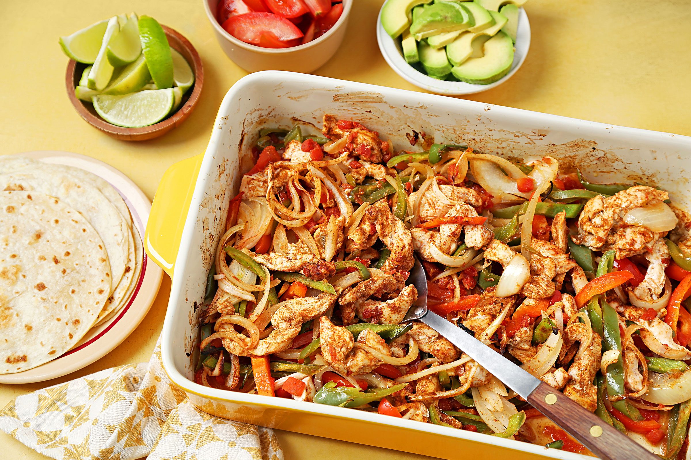 Baked Chicken and vegetables in a dish with tortillas on side