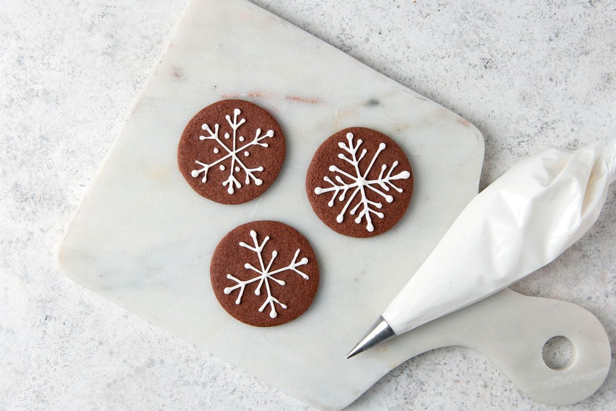 Using pastry bags and small round tips, decorate cookies