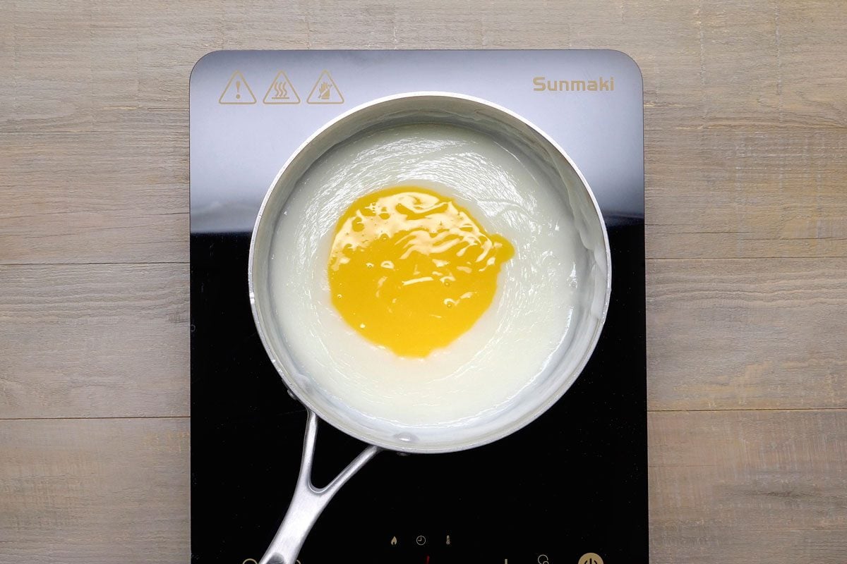In a small bowl, whisk a small amount of hot mixture into egg yolks