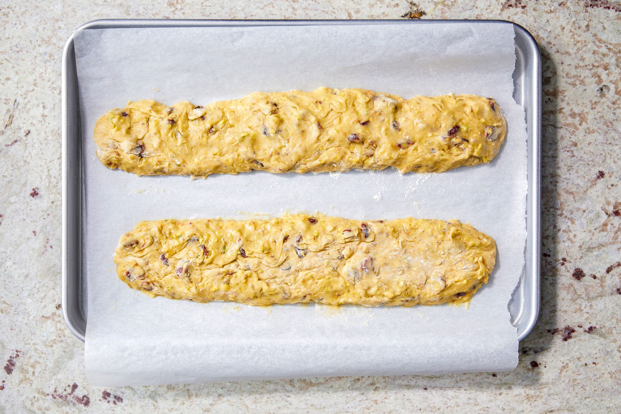 Divide dough in half; With floured hands; shape each half into a 12-inch x 2-inch rectangle on a parchment-lined baking sheet