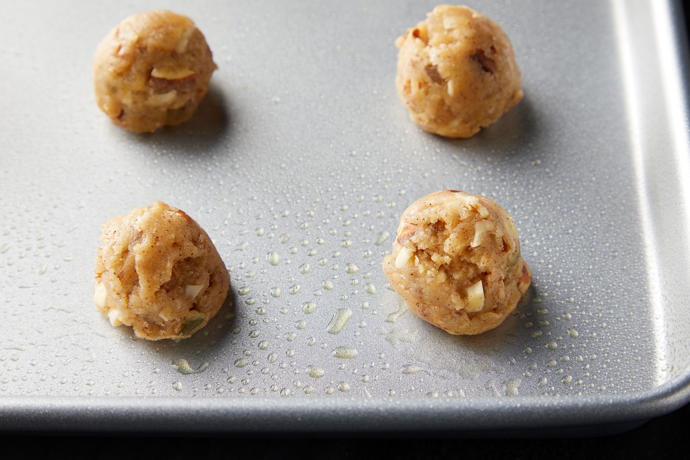 Cookie dough mixture shaped into half inch balls and placed on greased baking dish