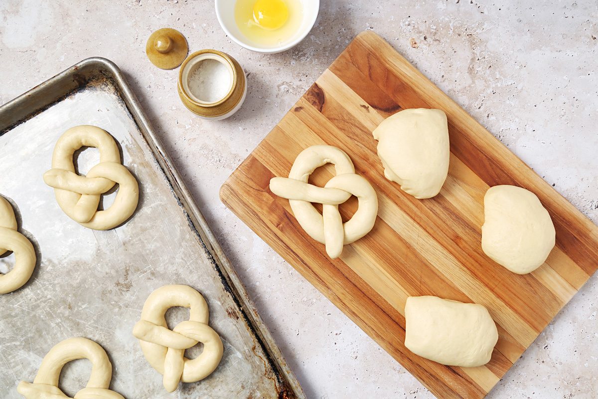 dough on a chopping board being shaped into pretzels