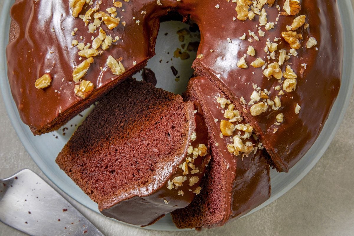 Close shot of Chocolate Chiffon Cake; placed on a plate; cut into slices; cake knife; marble surface;