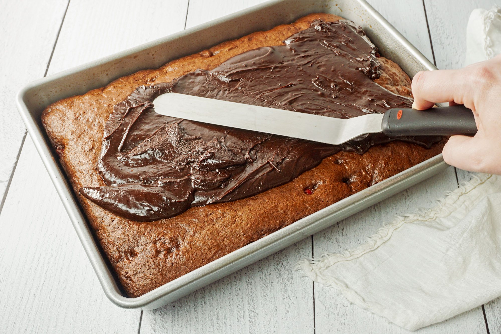 pour the warm frosting over the cake, using an offset spatula to spread it into an even layer