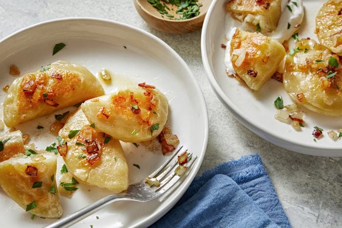 two white plates with pierogis