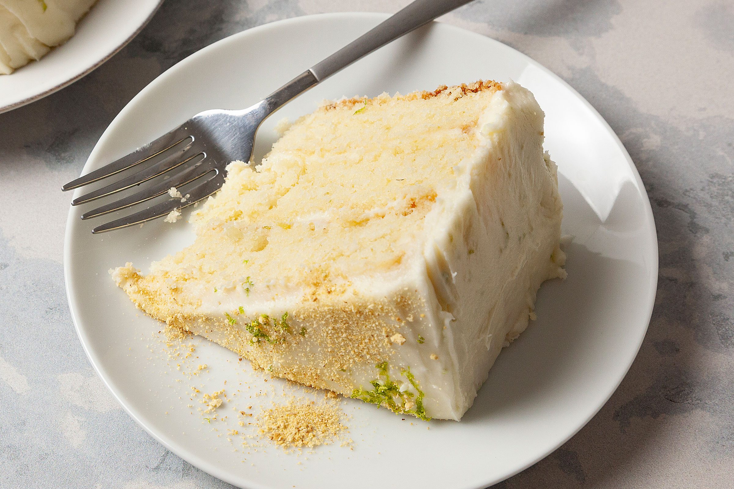 Key Lime Cake piece on a white plate with a fork
