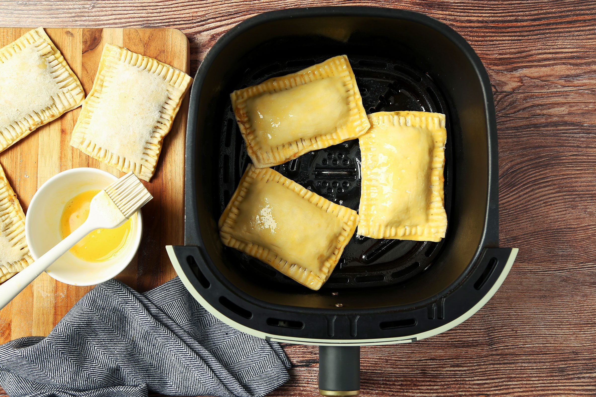 Meat pies in a single layer on a greased tray in the air-fryer basket