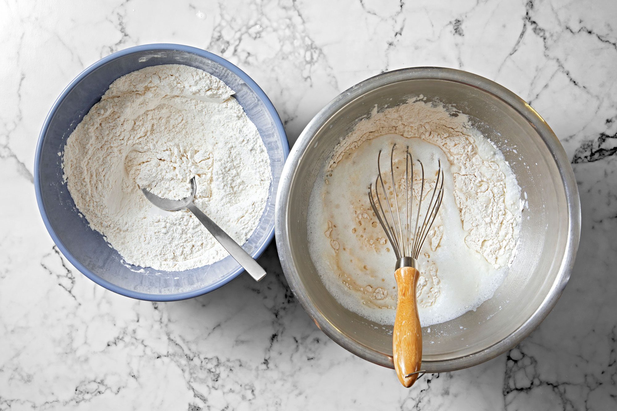 Overhead shot of a large bowl; dissolve yeast and 1 teaspoon sugar in 1 cup warm water; Let stand for 5 minutes; add remaining 3 cups water; beat in the milk powder and 5 cups flour until smooth; cover and let rise in a warm place until bubbly about 20 minutes; whisk tool; spoon