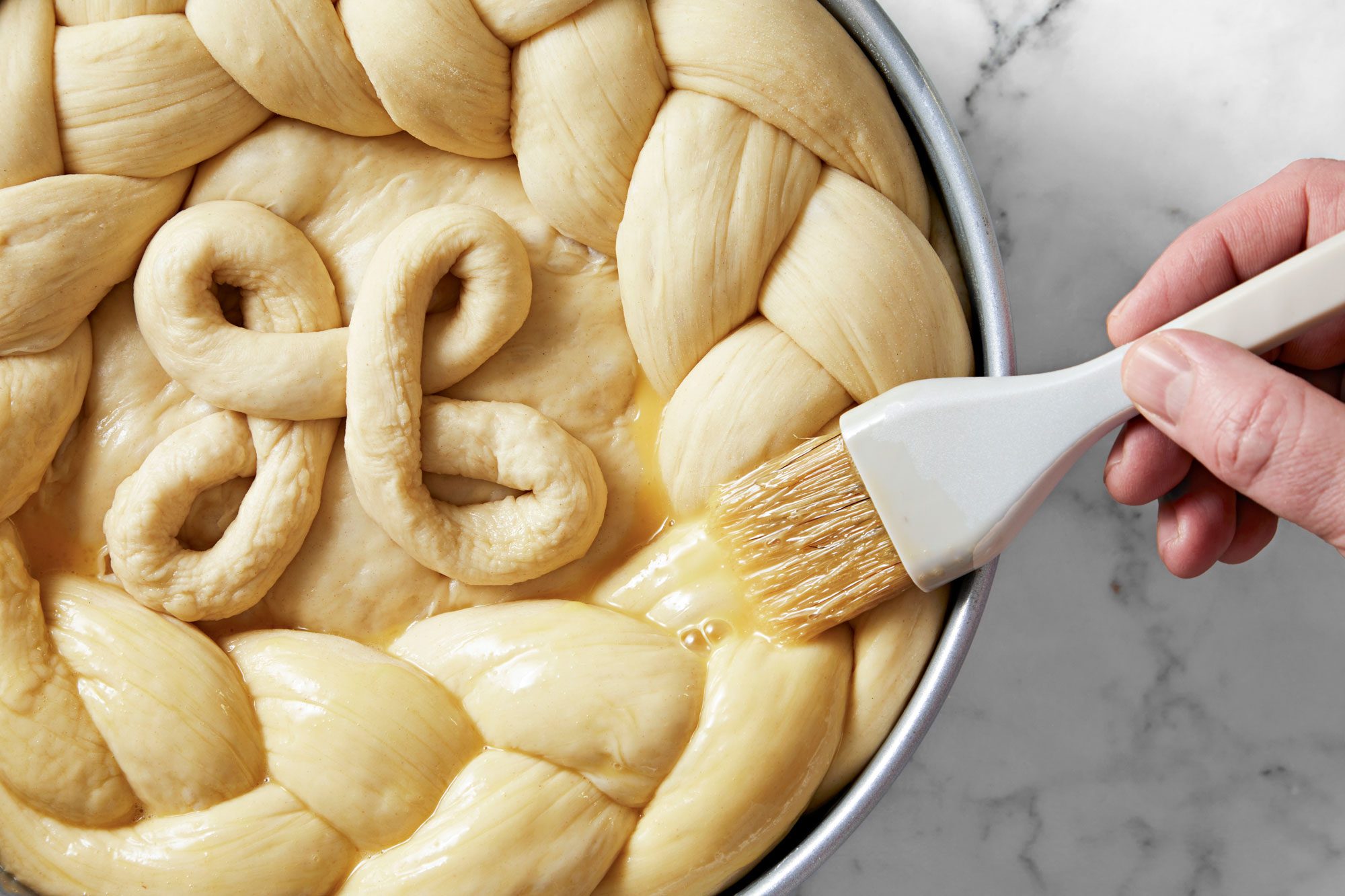 Close shot; For glaze; in a small bowl beat egg and water; brush over dough; bake at 350 degree for 50-60 minutes or until golden brown; marble surface