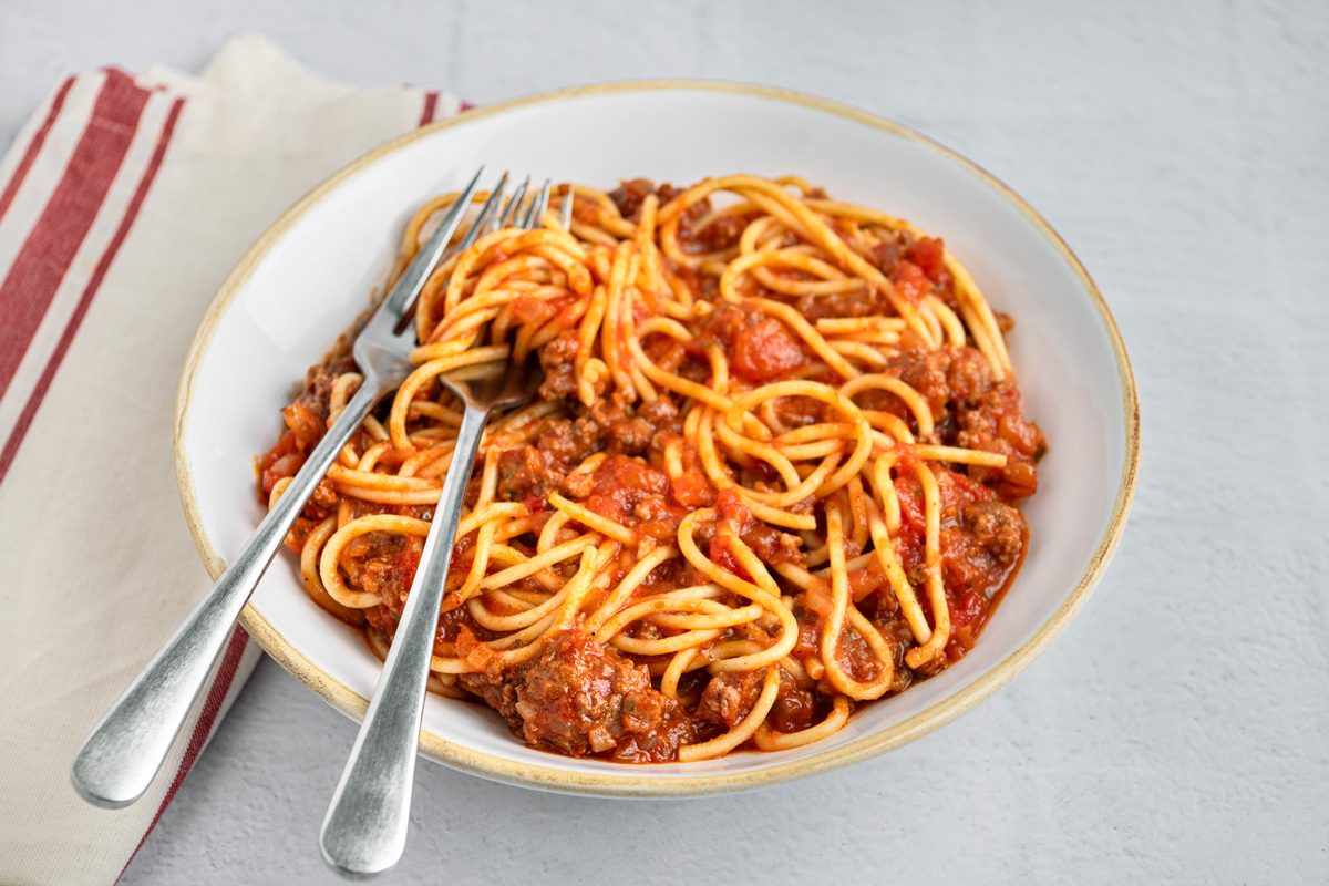 spaghetti mixed with sauce in a bowl