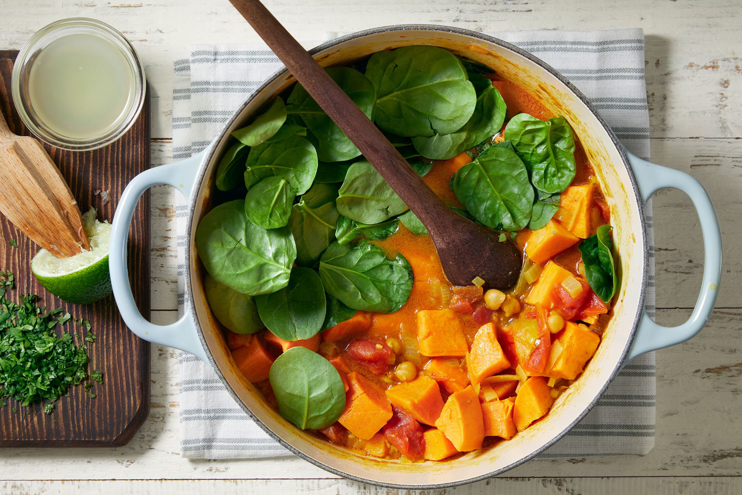 Added spinach leaves to sweet potato curry in a Dutch oven