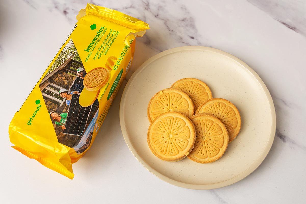 Package of lemonades Girl Scout Cookies next to several cookies on a plate