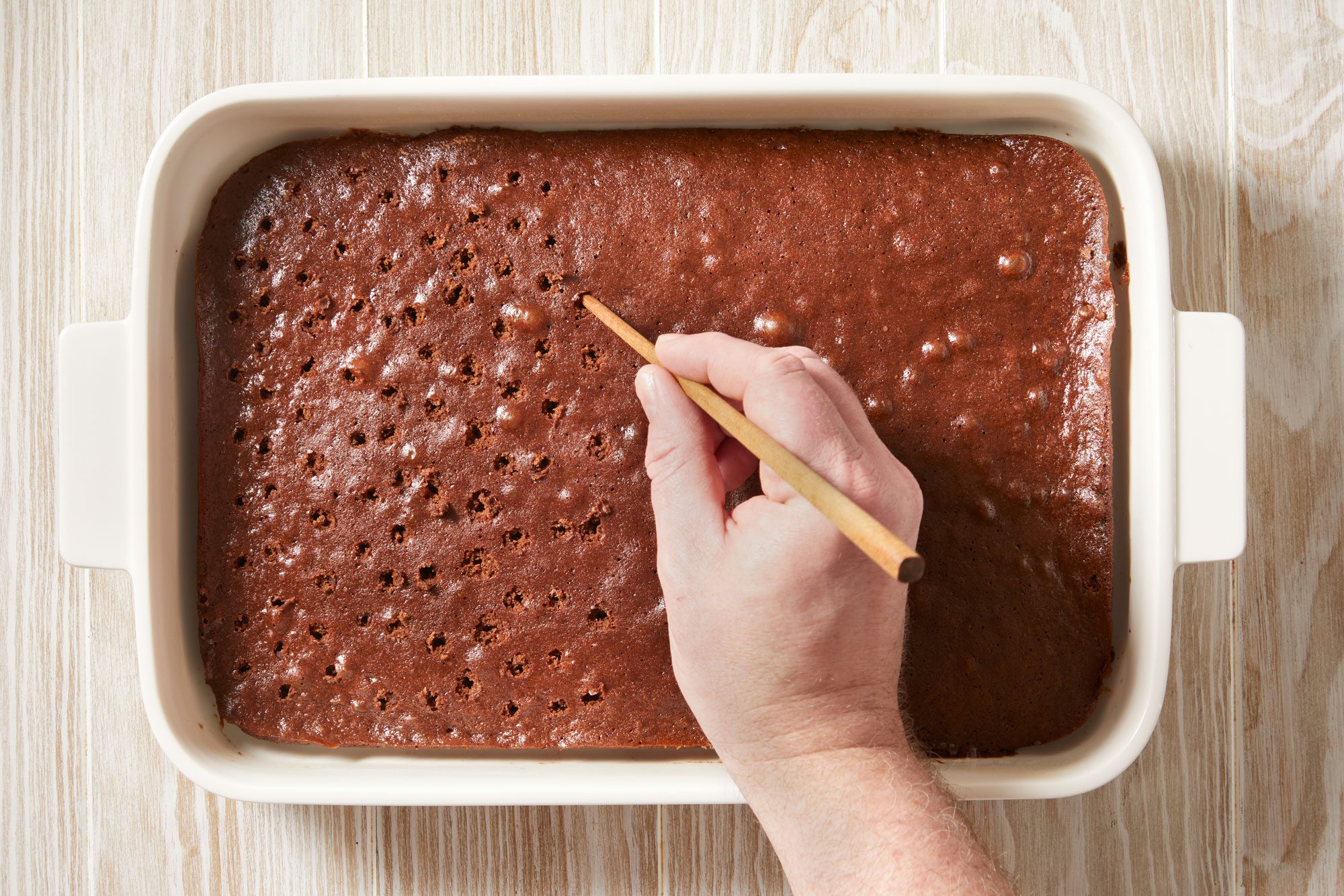Poke holes in cake with the end of a wooden spoon or chopstick.