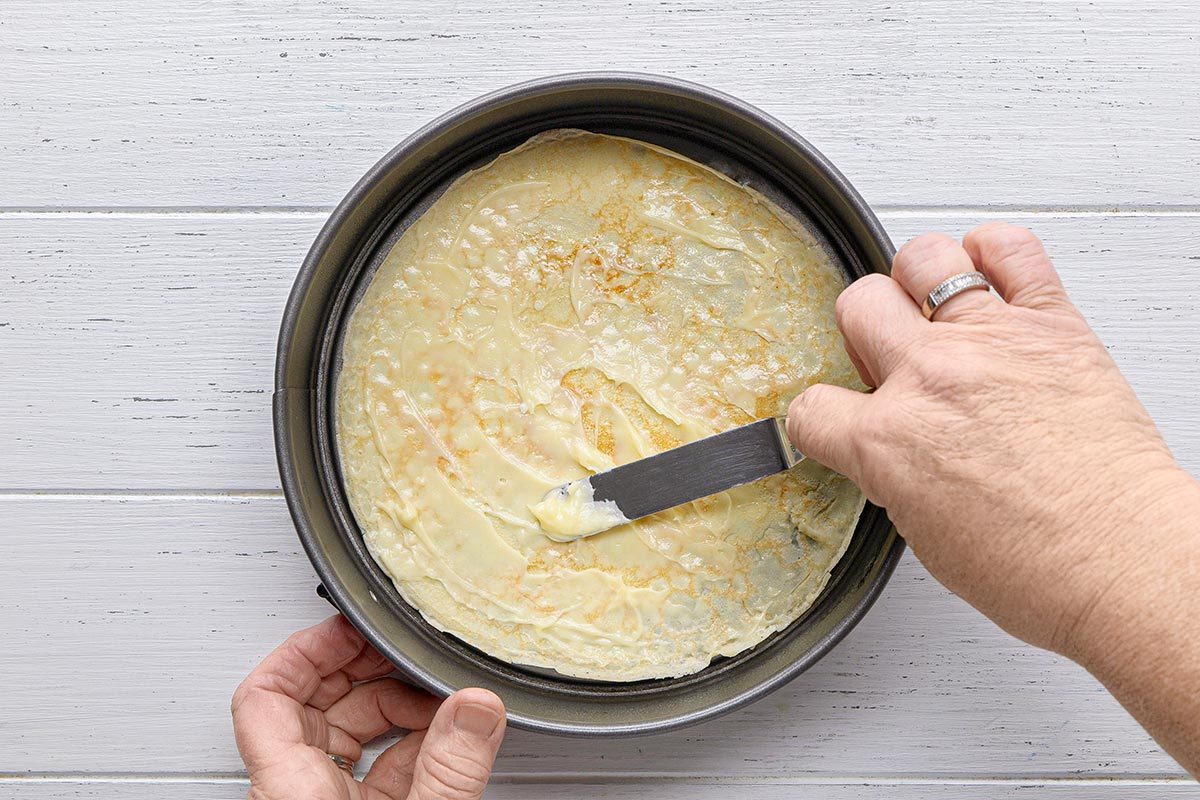 pastry cream being applied on a Crepe Cake