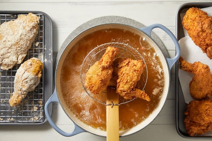 Frying battered chicken in hot oil in a dutch oven