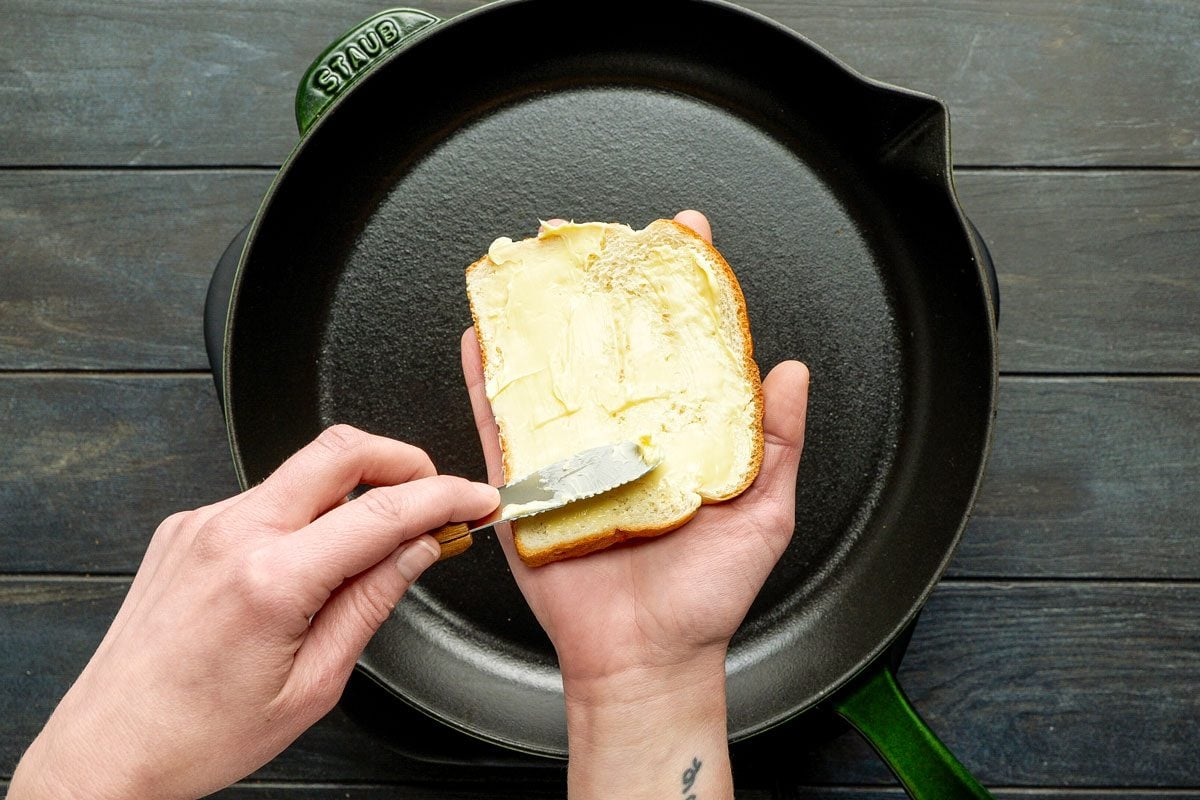 Spread butter on bread to grill on a pan