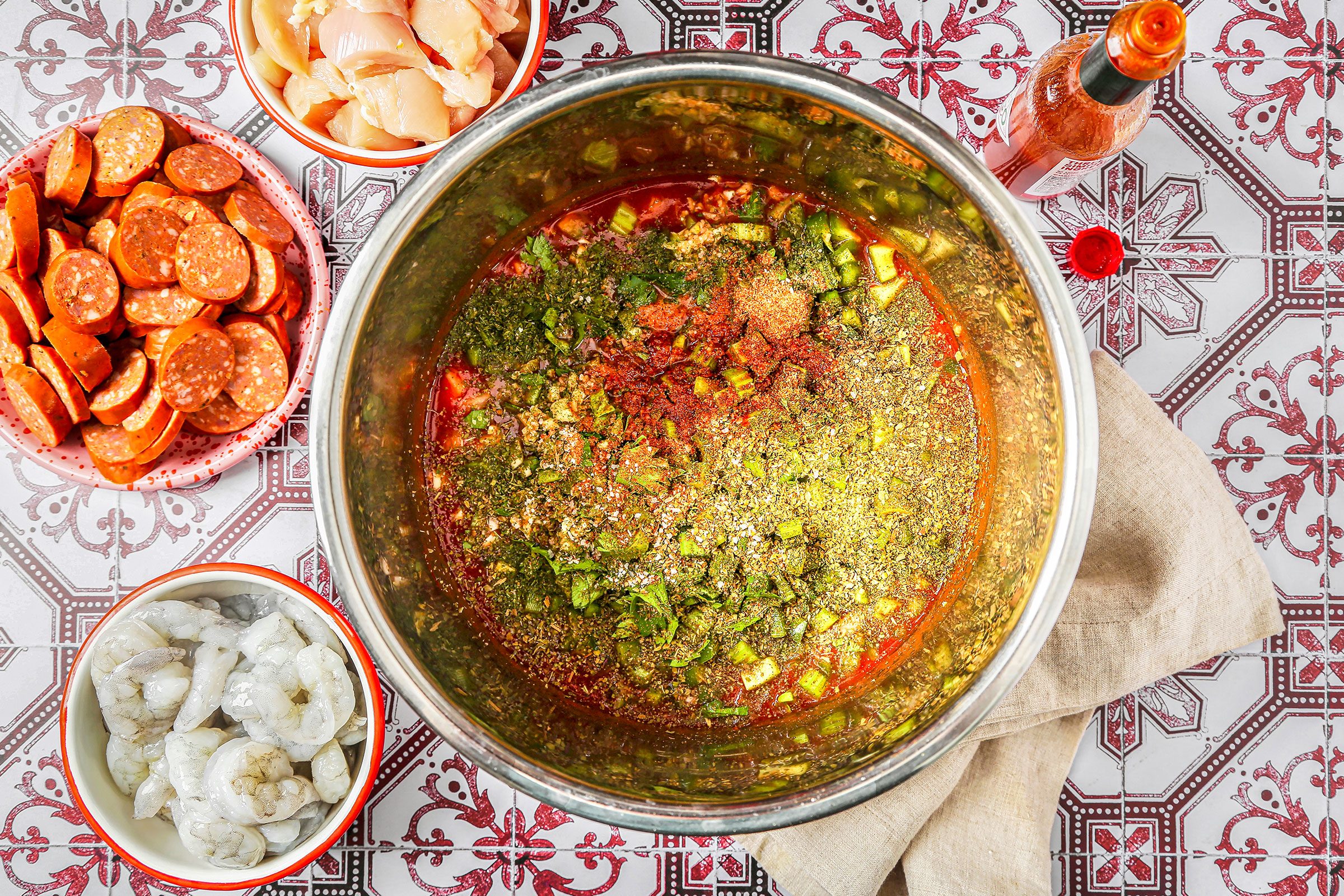 Broth and tomato paste with celery, green peppers, onion, garlic, parsley, basil, oregano, salt and pepper sauce in a cooker