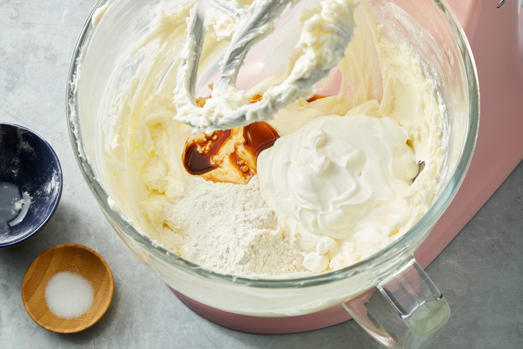Close shot of a large bowl beat cream cheese and sugar until smooth; on a grey surface;