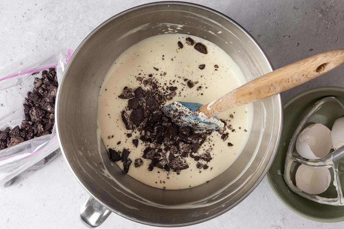 Sugar, Eggs and oreo being mixed in a large bowl