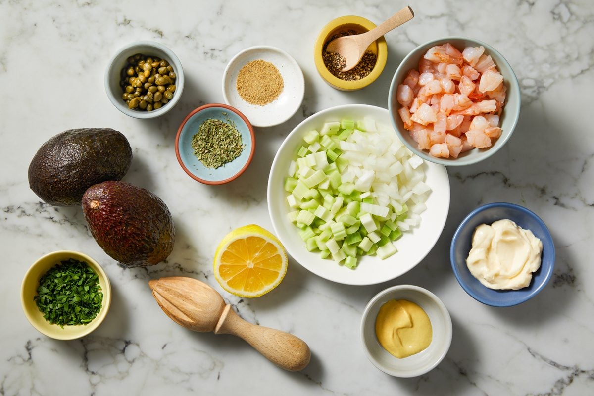 Overhead shot of all ingredients for Shrimp Salad Stuffed Avocados; all set on marble surface;