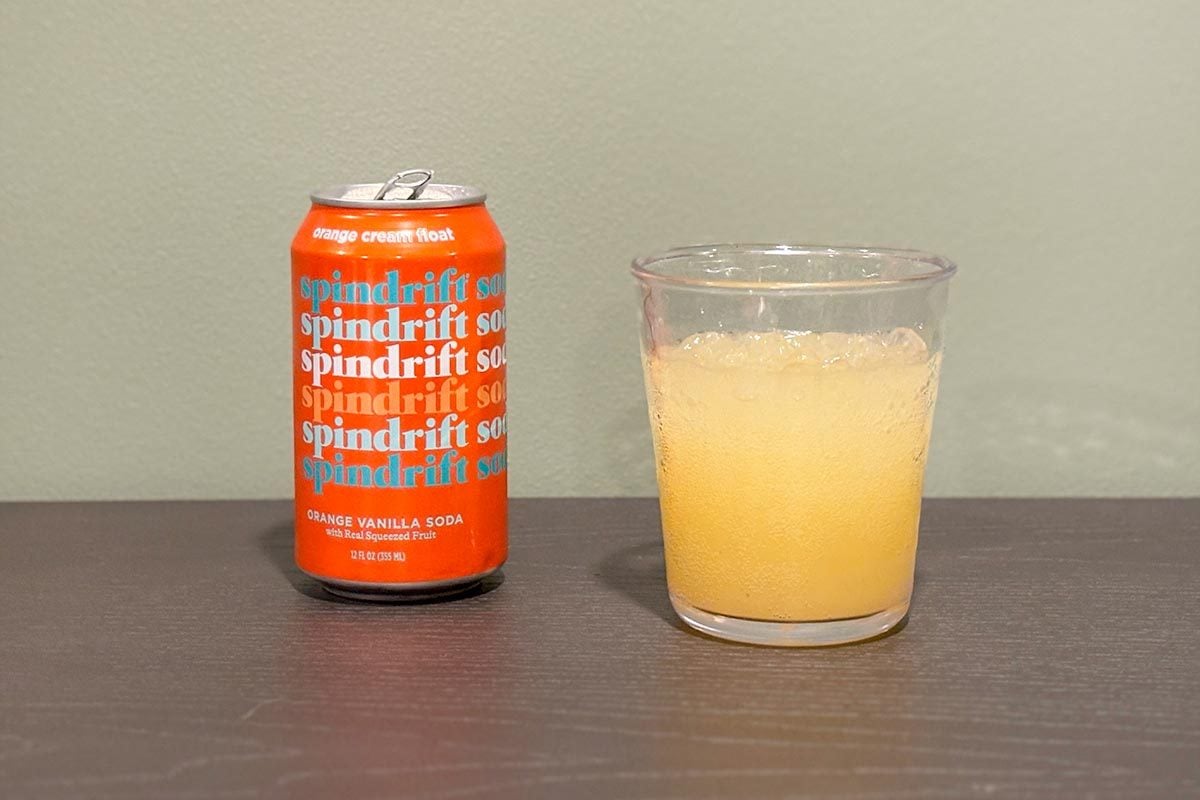 A glass full of Spindrift Soda with can ona table