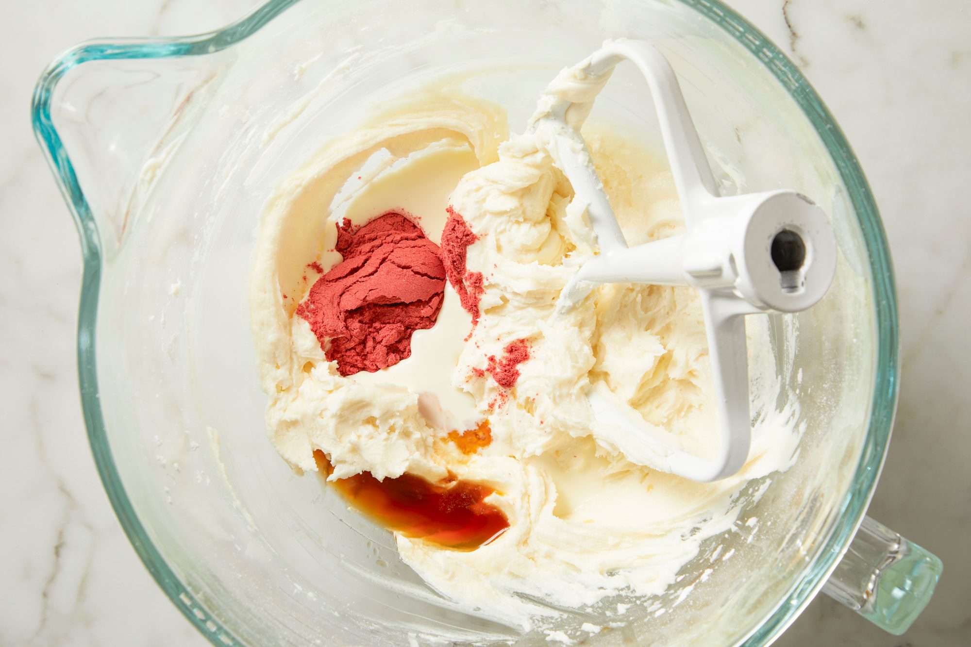 Overhead shot; To make filling, cream butter in a stand mixer fitted with whisk attachment; slowly add confectioners' sugar until incorporated; beat in strawberry powder; heavy cream; vanilla; salt and if desired, enough food coloring to achieve desired color; mix until smooth; marble surface;