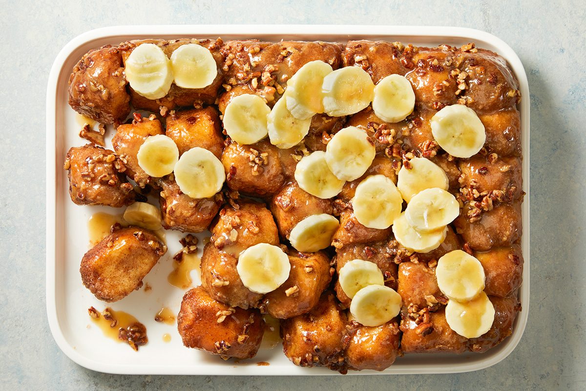 Overhead shot of Upside-Down Banana Monkey Bread; Top with sliced banana; drizzle with reserved glaze