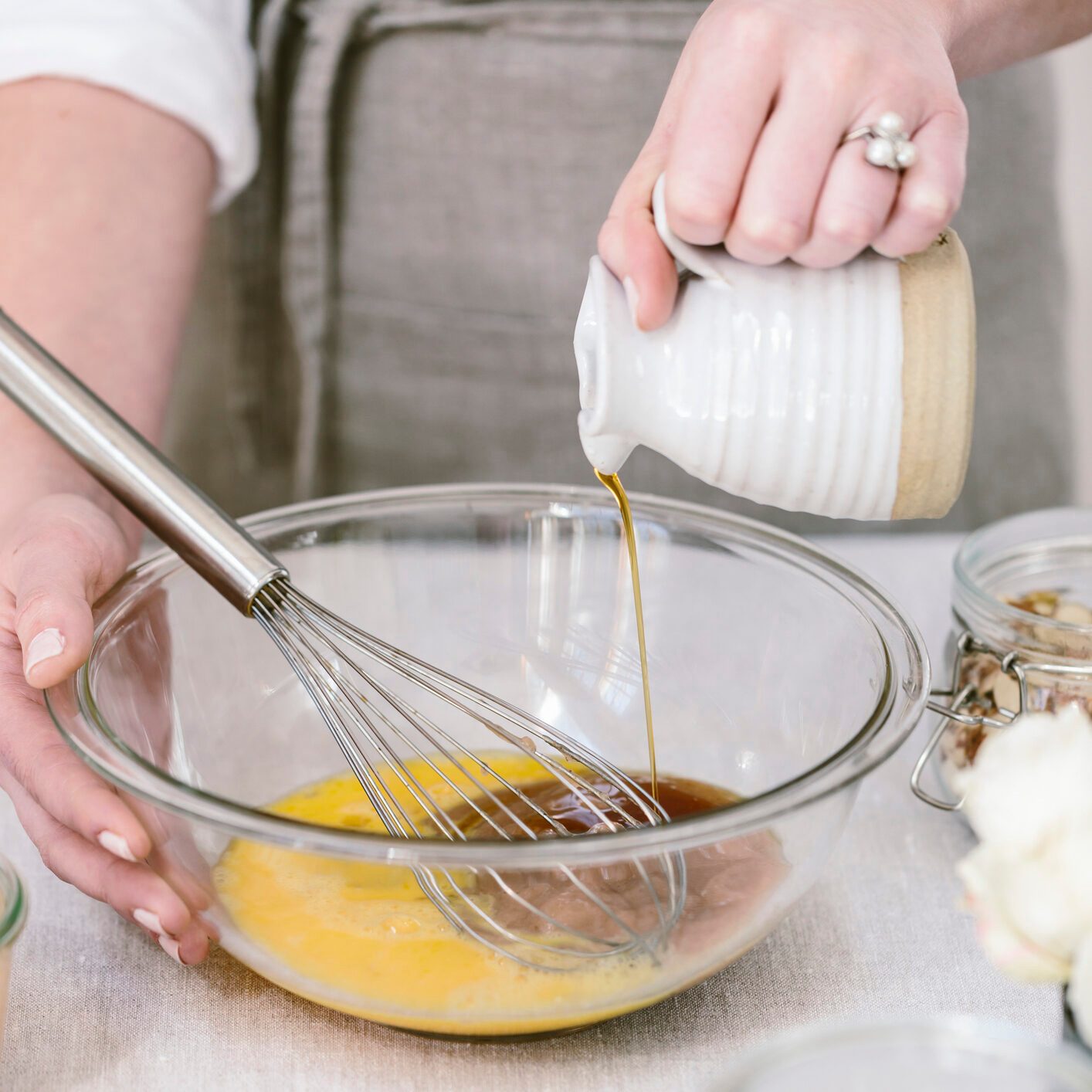 Baker pours maple syrup into cake batter